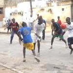 a gang of menaces playing football in the street disturbing the neighbourhood