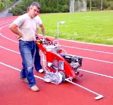 a line marker (person) marking line on a sports track with a line marker (machine)