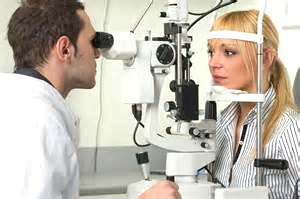 an optician (L) testing a patient's vision