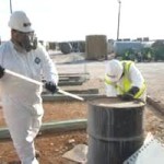 fully protected hazardous waste removers at work
